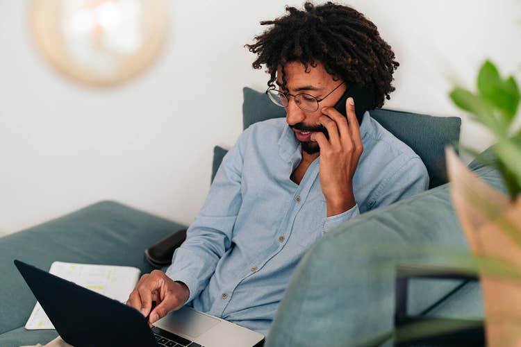 A person reviews an affidavit on their laptop while talking on their phone