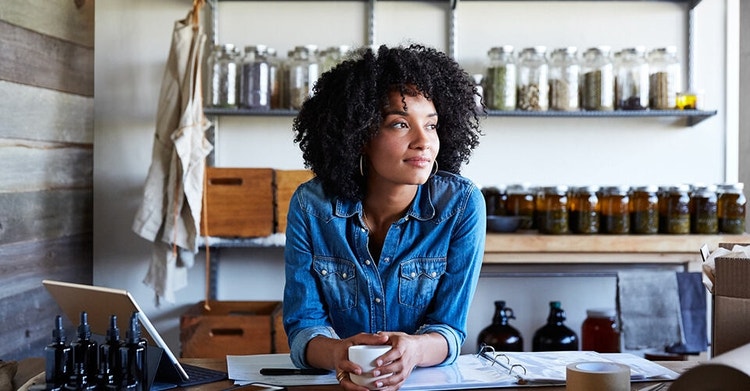 A small business owner envisions the future while holding a cup of coffee