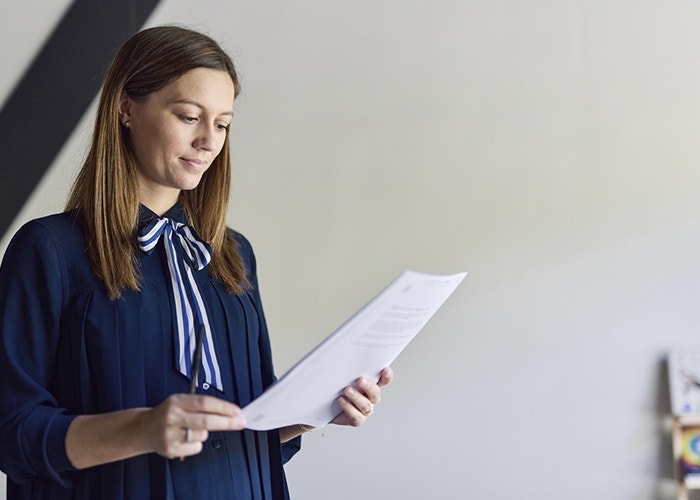 A person reviewing documents that they are holding