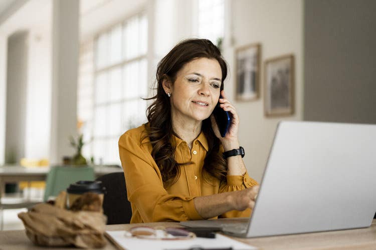 A businessperson discussing their sales process with a colleague by phone