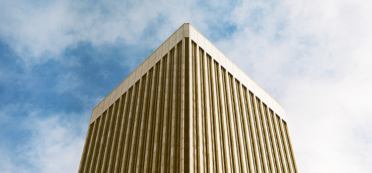 The top of a tall building and the blue sky behind it as an example of perspective photography