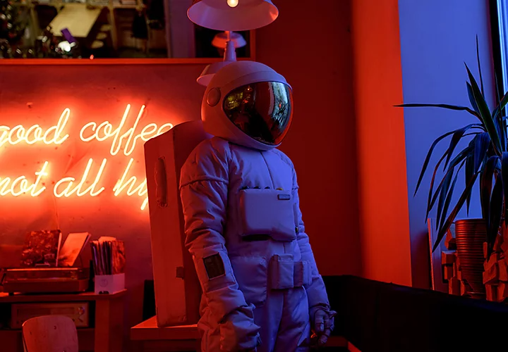 A model in an astronaut suit standing in a coffee shop