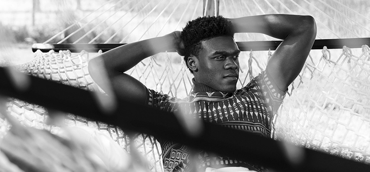 A black-and-white photo of a person relaxing in a hammock