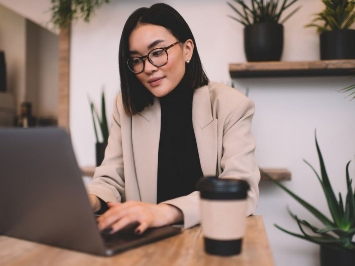 A person in an office with lush green plants converting a PDF to a Word doc on a Mac using Adobe Acrobat