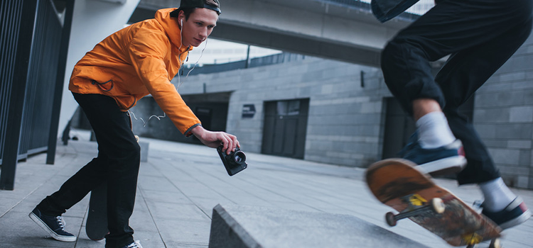 A photo of a sports photographer taking an action photo of a skateboarder.