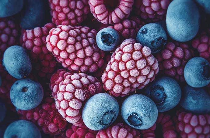 Macro picture of a pile of frozen blueberries and raspberries