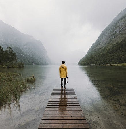 A photographer, standing on a gloomy pier