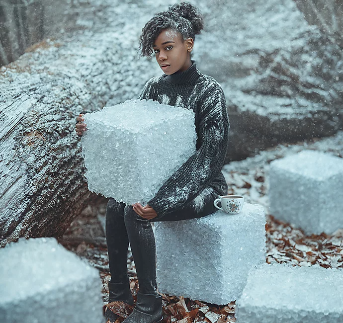 A model sitting on a large block of ice while holding a large block of ice