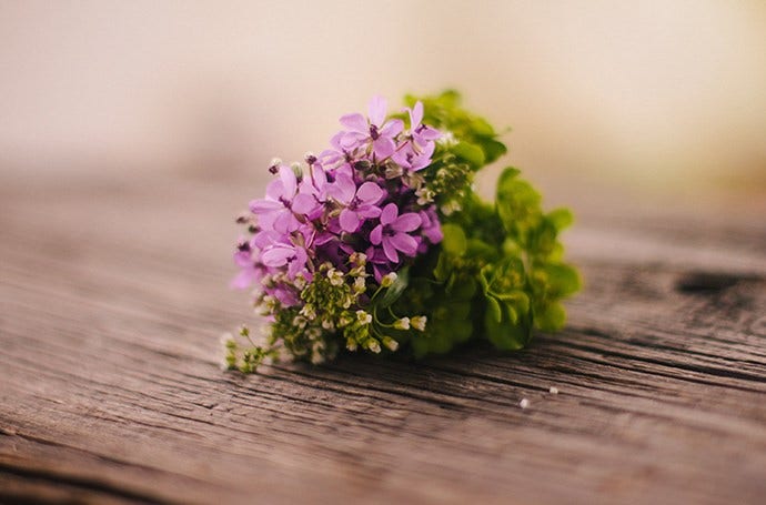 Rustic, short depth of field image of purple flowers on a wooden table