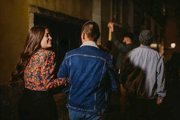 A photo of a group of friends walking down the street at night.