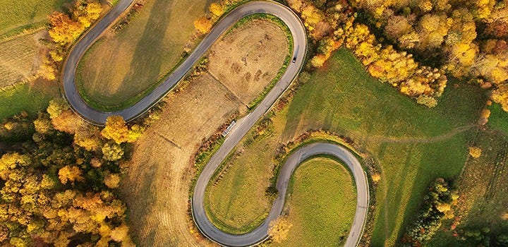 Drone photo of winding road in the autumn countryside.