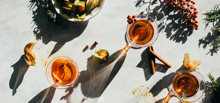 A flat lay photo of cocktail drinks and ingredients on a table