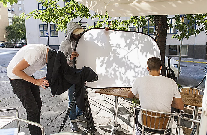 Foto von drei Personen, die an einem Film-Set arbeiten