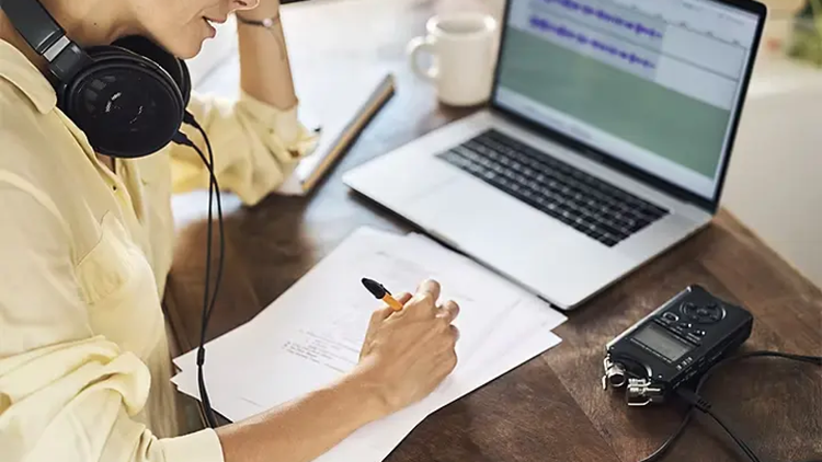 Person, die vor einem Computer sitzt und über den Prozess der Filmproduktion nachdenkt