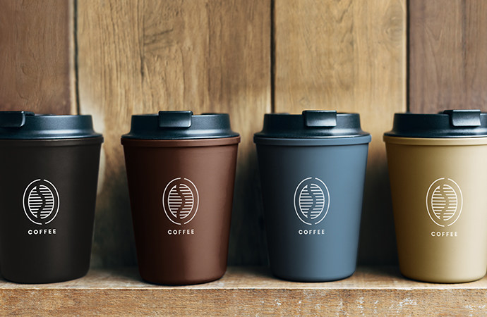 Coffee bean logo design idea on four distinct, brand-coloured coffee cups.