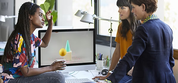 Design thinkers brainstorming ideas together at a designer's desk