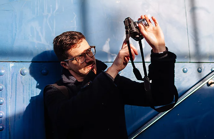 A person taking a photo outside with a mirrorless camera