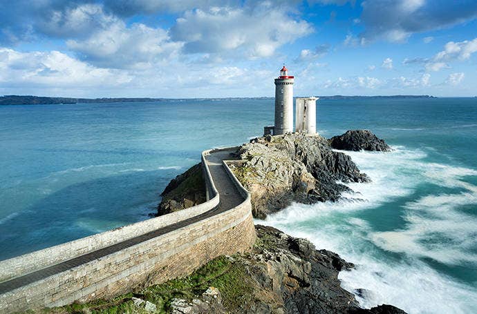 Landscape photograph of a lighthouse at the end of an old road