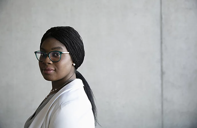 A person standing sideways to camera and looking at camera for a corporate headshot photo