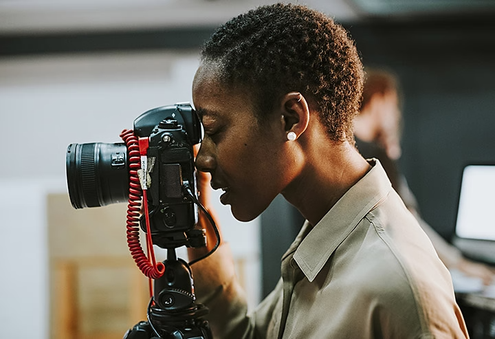 An image of a person looking through the viewfinder of a camera.