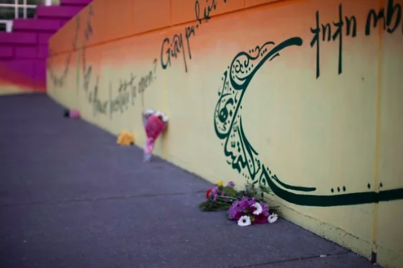 A photo of flowers sitting against a wall outside.