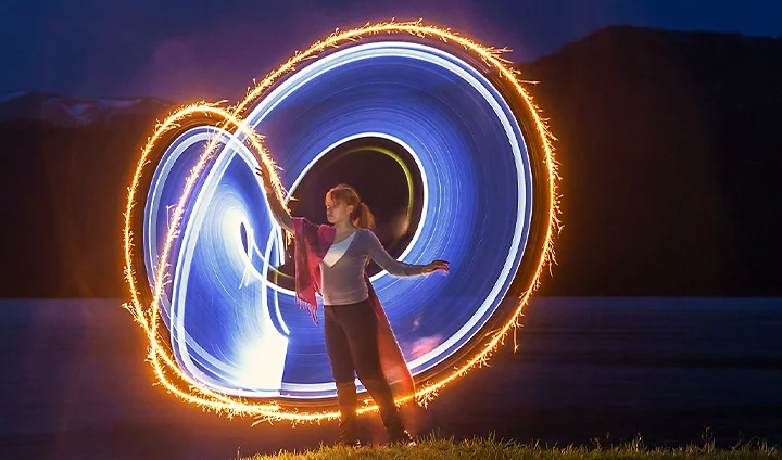 Multiple cameras pointing at a spiraling light at nighttime to create a light painting