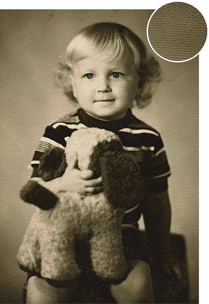 An old portrait photo of a child showing texture in the paper which reduces the quality of the image