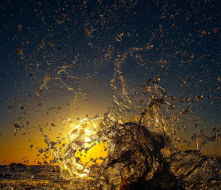 Water splashing in front of a sunset