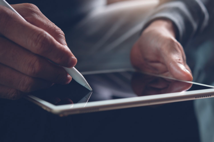 Manos de hombre firmando en una tablet