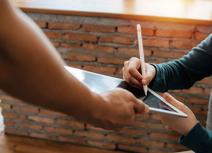 Mano de un hombre agregando su firma electrónica a un documento digital