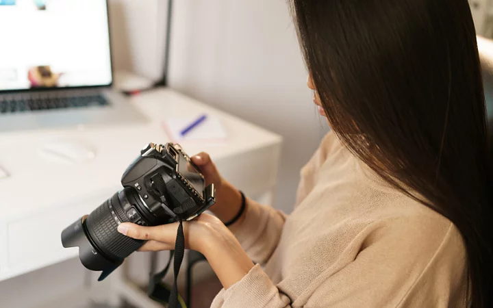 A photo of a photographer looking at their camera.