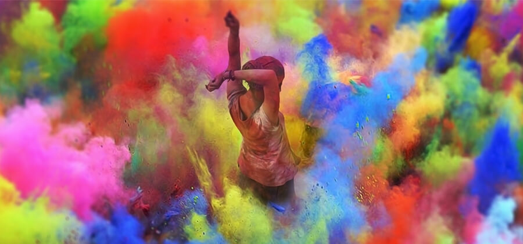 A woman stands in the middle of an explosion of colors.