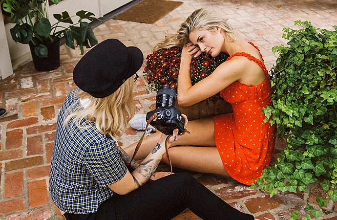 An aerial view of a photographer talking with a model posing on a prop