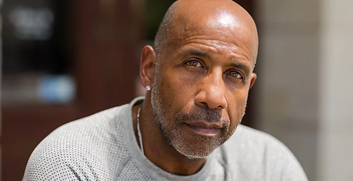 A portrait photo of a person sitting outside.