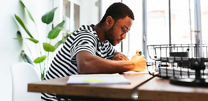 Iemand die aan een bureau met de hand logo-ontwerpen tekent