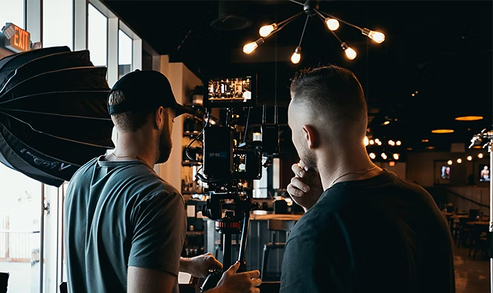 Een videograaf en een regisseur die een camerashot voor een commercial instellen