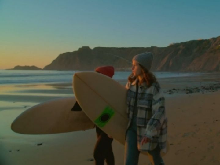 Video: A video of surfers walking on the beach with a filter applied.