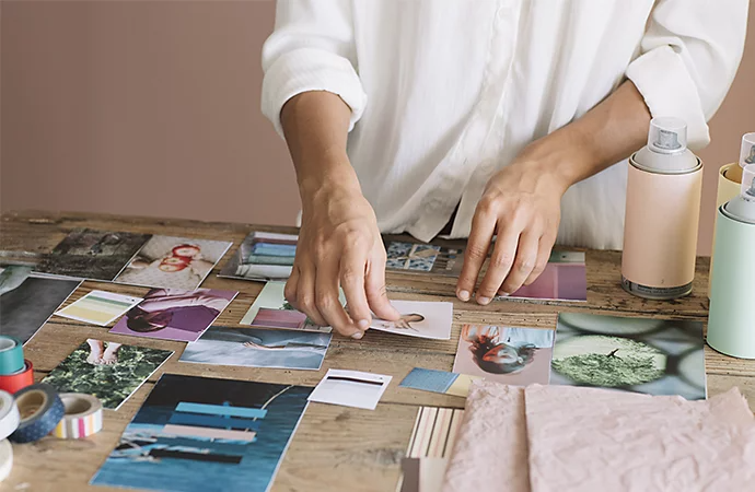 A photographer laying out printed photos on a tabletop