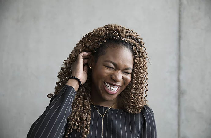 A person laughing and posing for a corporate headshot photo