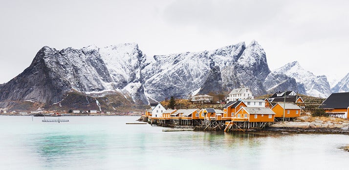 Mountains tower over a coastal village in this landscape photo