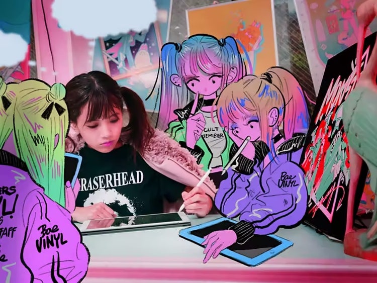 A photo of a young girl in a black t-shirt and pigtails creating on an iPad while surrounded by animated versions of herself drawing