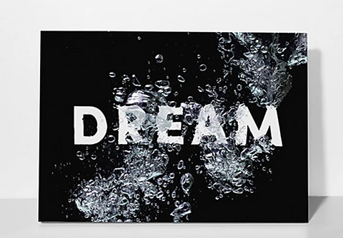 A painting of the word "DREAM" breaking through shattered glass.