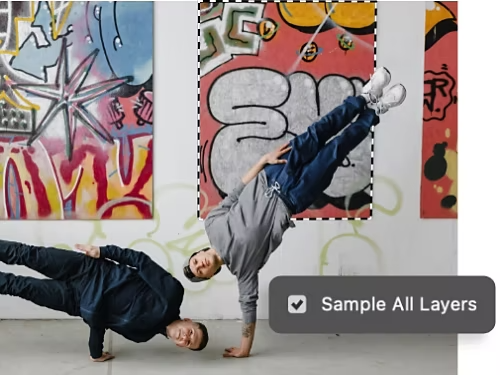 Sample All Layers setting superimposed on a photo of two people doing acrobatics. A painting in the background has been selected using the Magic Wand tool.