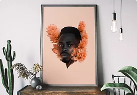 A picture of art sitting on a desk in a room. The art features a person with flowers framing their head.