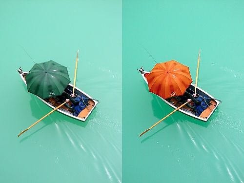 The umbrella of a boat being rowed is changed from green to orange to juxtapose against the green water