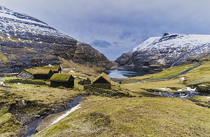 A photo of moss-covered stone buildings in a grassy countryside