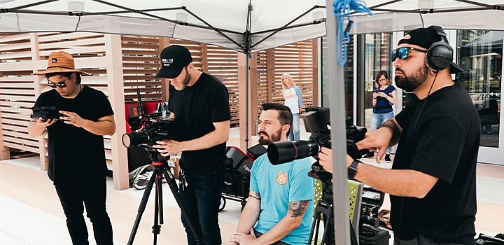 Equipe de produção montando câmeras para a filmagem de um comercial