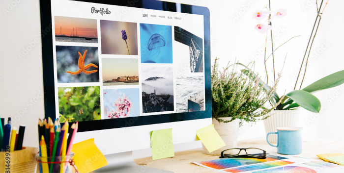 A desk computer shows a colorful digital portfolio