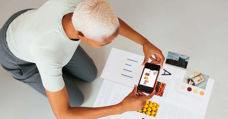 A person taking a photograph of a data graph with their smartphone