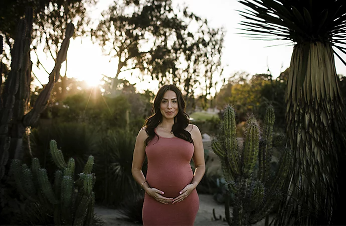 A pregnant parent posing outside for a maternity photo